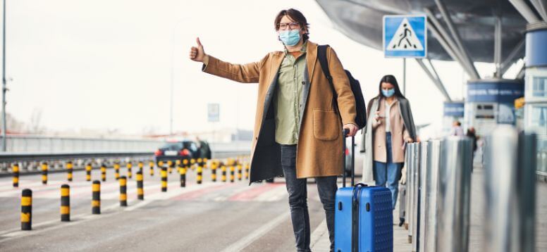 Stylish young man in medical mask catching a taxi at Buenos Aires